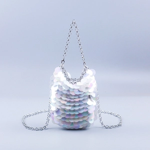 Detailed macro view of white holographic sequins and silver chain strap on the handbag