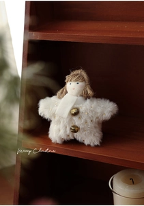 Macro shot of plush star angel ornament with gold dots and bells on wooden shelf