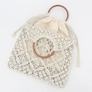 Handwoven cotton rope beach bag with round wooden handles and drawstring pouch