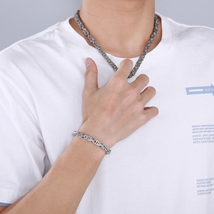 Silver stainless steel Byzantine chain necklace and bracelet set worn by a male model