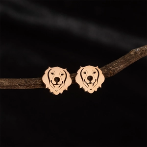 Polished rose gold dog head stud earrings displayed on a natural wooden branch