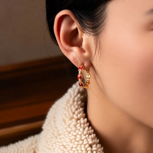 Macro view of 18k gold plated earring with red enamel inlay and micro-pave crystals