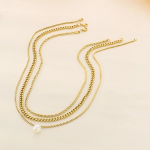Detail of gold-plated layering set with curb chain, rope chain and single pearl pendant