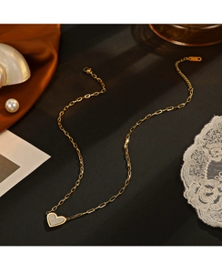 Detailed close-up of a 14K gold plated heart necklace with mother of pearl inlay on silk