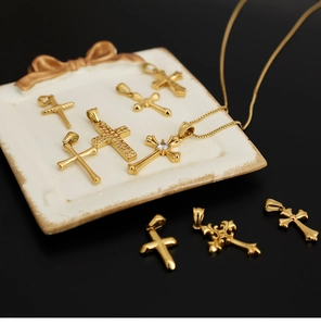 Macro shot of 18K gold plated titanium steel cross pendants with zircons on ceramic tray