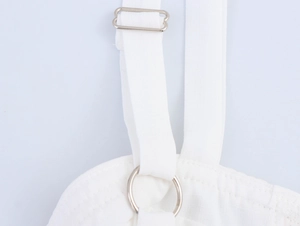 Detail of adjustable white dress shoulder strap with silver metal buckle and ring