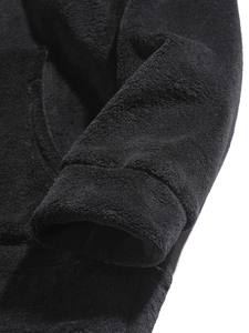 Close-up of black coral fleece fabric texture and cuff detail on a men's winter hoodie