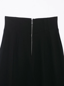 Detailansicht der schwarzen Hose mit hoher Taille, Metallreißverschluss und Taillenfalten