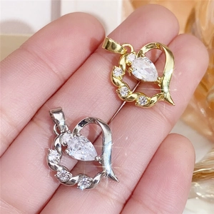 Macro shot of gold and silver heart pendants with sparkling cubic zirconia inlay detail