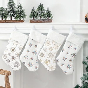 Lot de quatre chaussettes de Noël en peluche blanche aux motifs de flocons dorés