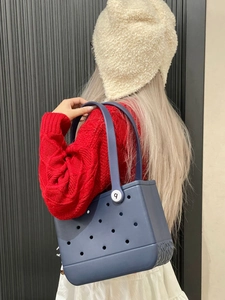 Close-up of blue EVA beach tote with hole design showing side texture and handle