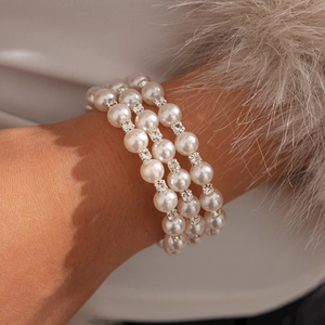 Close-up of three-layer faux pearl bracelet with rhinestone spacers on a fur cuff
