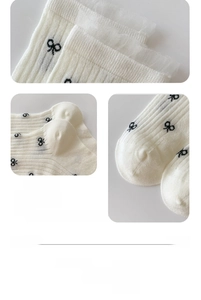 Detail of seamless toe and black bow patterns on breathable white knit mesh socks