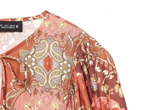 Dettaglio del top bohémien con stampa paisley, motivo floreale etnico e cuciture del collo