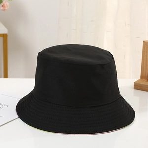 Detailed close-up of a classic black cotton canvas bucket hat on a white desk