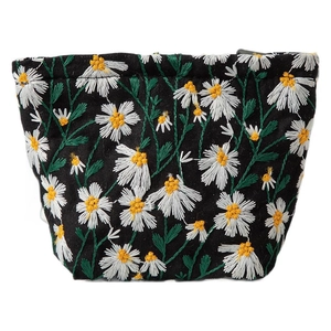 Large black canvas cosmetic bag with daisy embroidery and secure zipper closure