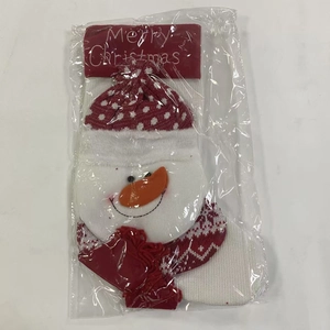 Detailed view of a red and white knitted Christmas stocking with a snowman pattern in packaging