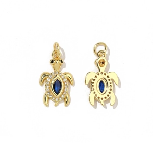 Vue détaillée du pendentif tortue dorée avec pierre bleue et accents de zircone