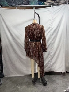 Dettaglio di un abito bohémien in chiffon con stampa paisley, collo alto e orlo asimmetrico
