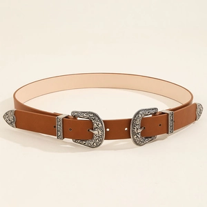 Detail of vintage brown leather belt with dual silver western floral engraved buckles