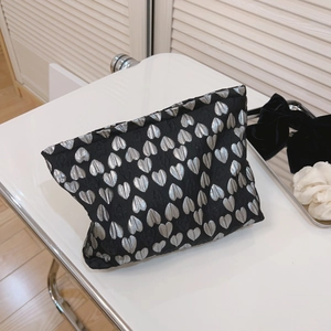 Minimalist canvas storage bag with silver heart jacquard pattern on black fabric background