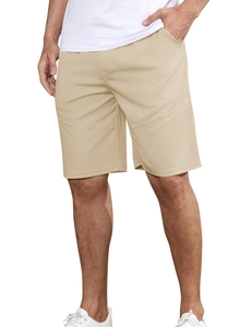 Detail of khaki loose sport shorts showing smooth plain weave fabric and side pocket design