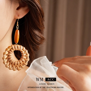 Boucles d'oreilles bohèmes en rotin et perles de bois portées pour un style ethnique