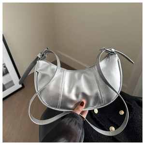 Detailed view of metallic silver crescent bag in high-quality PU leather with adjustable strap