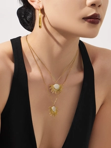 Détail d'un collier superposé tournesol doré serti de zircons sur le cou d'un mannequin