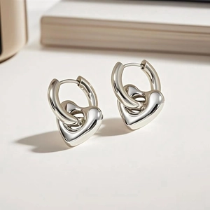 Detailed view of polished silver heart earrings with a minimalist sleek metallic finish
