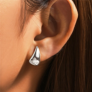 Close-up of a silver water drop earring worn by a model to show actual size and fit