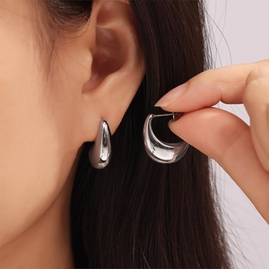 Sleek silver teardrop stud earrings in polished 18k gold plated stainless steel on model