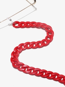 Detail of chunky red acrylic eyeglass chain with large links on white background