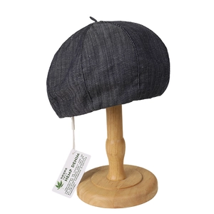 Lightweight hemp denim beret in dark grey on wooden stand with high texture detail