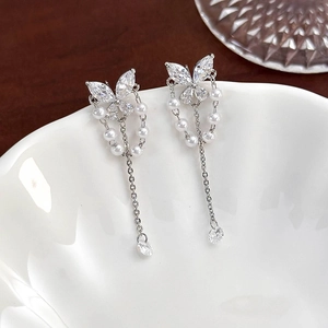 Detailed macro view of silver butterfly long chain earrings with marquise zircon and pearls
