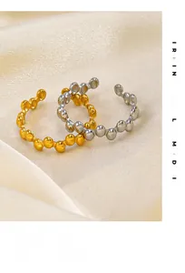 Macro detail of gold and silver beaded adjustable stainless steel rings on silk fabric