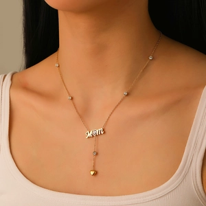 Détail du collier en Y doré avec pendentif lettres MOM et accents en zircons cœurs