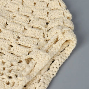Vue détaillée de la texture crochetée beige ajourée avec un tricot épais fait à la main