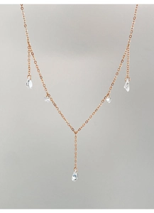 Detailed view of a rose gold Y-shaped necklace with dangling clear teardrop crystals