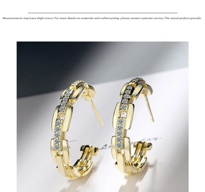 Macro shot of gold-plated chain-link hoop earrings featuring sparkling zircon stone inlays