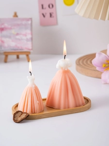 Detailed view of two coral wedding dress candles on a wooden tray for home decor