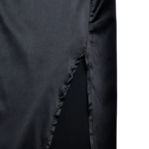 Close-up of black satin fabric texture featuring detailed stitching on a side slit detail