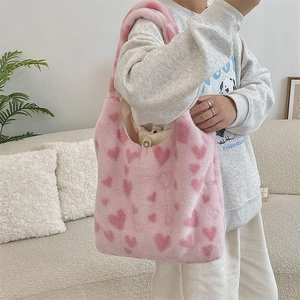 Detail of pink faux fur tote bag with heart pattern and magnetic snap closure