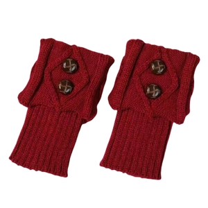 Close-up of red diamond knit leg warmers with two brown buttons on a white background