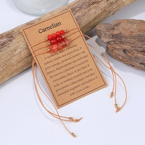Detalle de pulseras de cornalina en tarjeta de papel con decorado de madera real