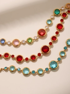 Detailed close-up of a gold bracelet featuring multi-color round cut cubic zirconia stones