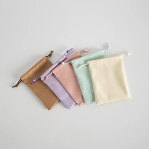 Close-up of five colorful velvet drawstring pouches in brown, lavender, and pastel tones