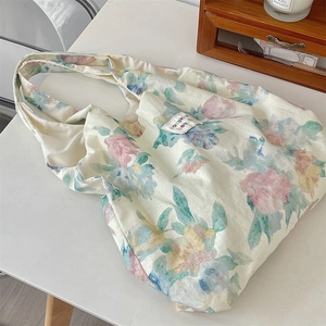 Close-up of floral print linen tote bag with fabric logo label and woven texture
