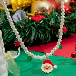 Christmas snowman and pearl necklace with red and green beads on a festive background