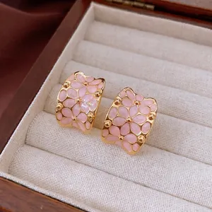18k gold plated floral stud earrings with pink enamel flower clusters on wood base